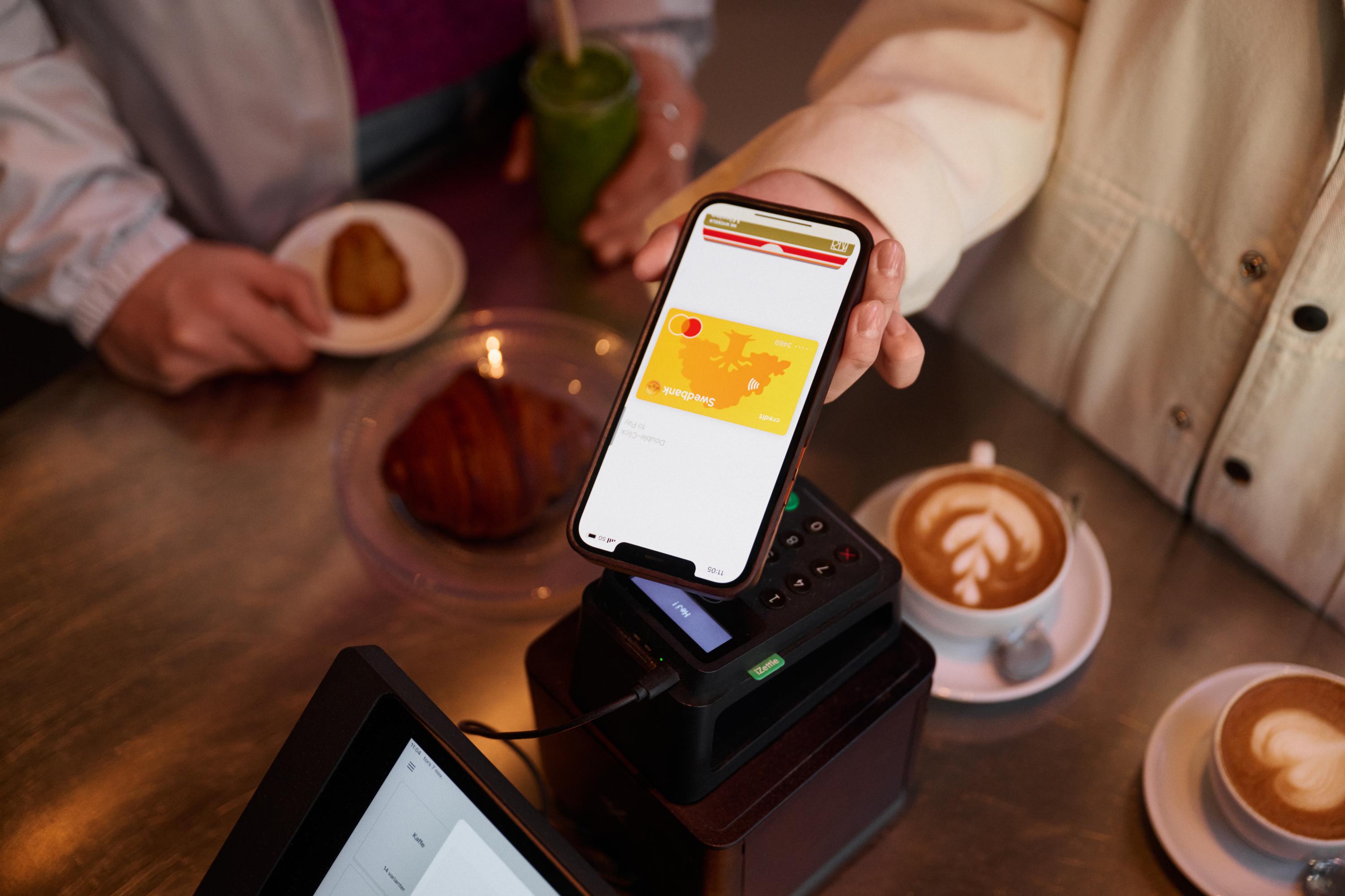 Person paying with a phone at a café 