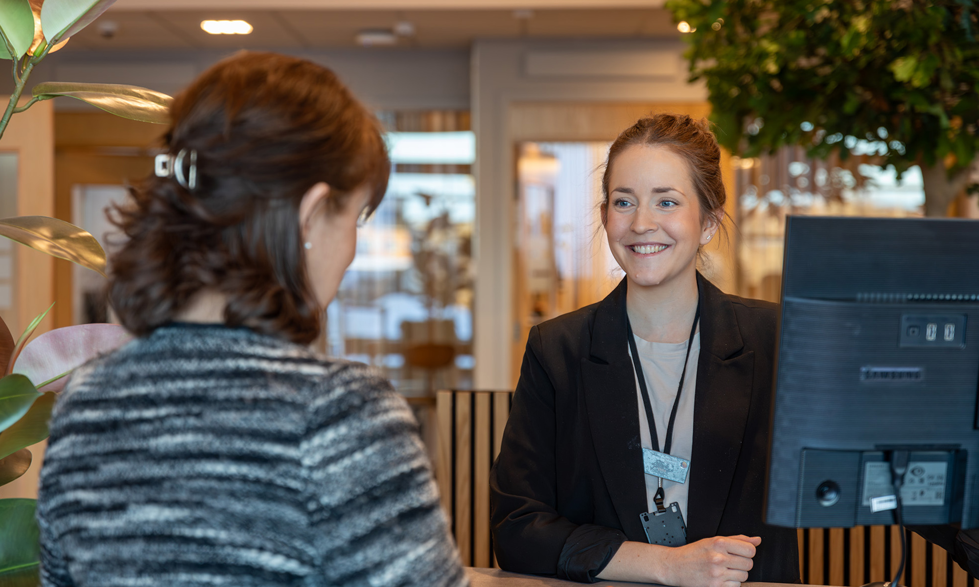 En kvinnlig banktjänsteman hjälper en kund