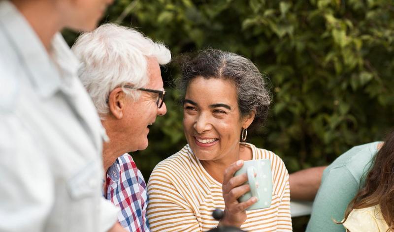 Smiling woman holding coffee cup with older man